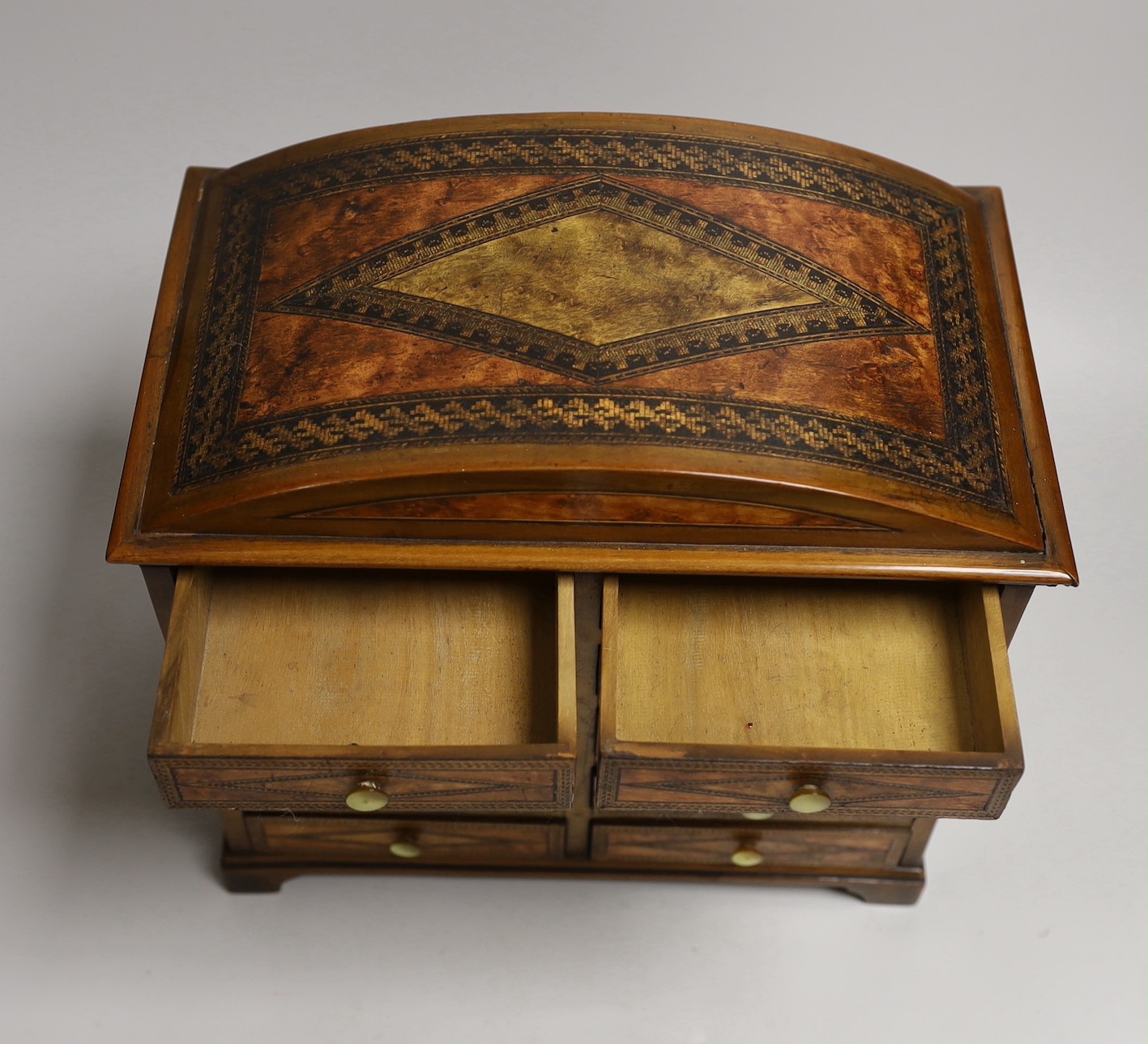 A Sorrento inlaid bird’s eye maple ten drawer miniature chest, 27cms x wide 26.5 cms high